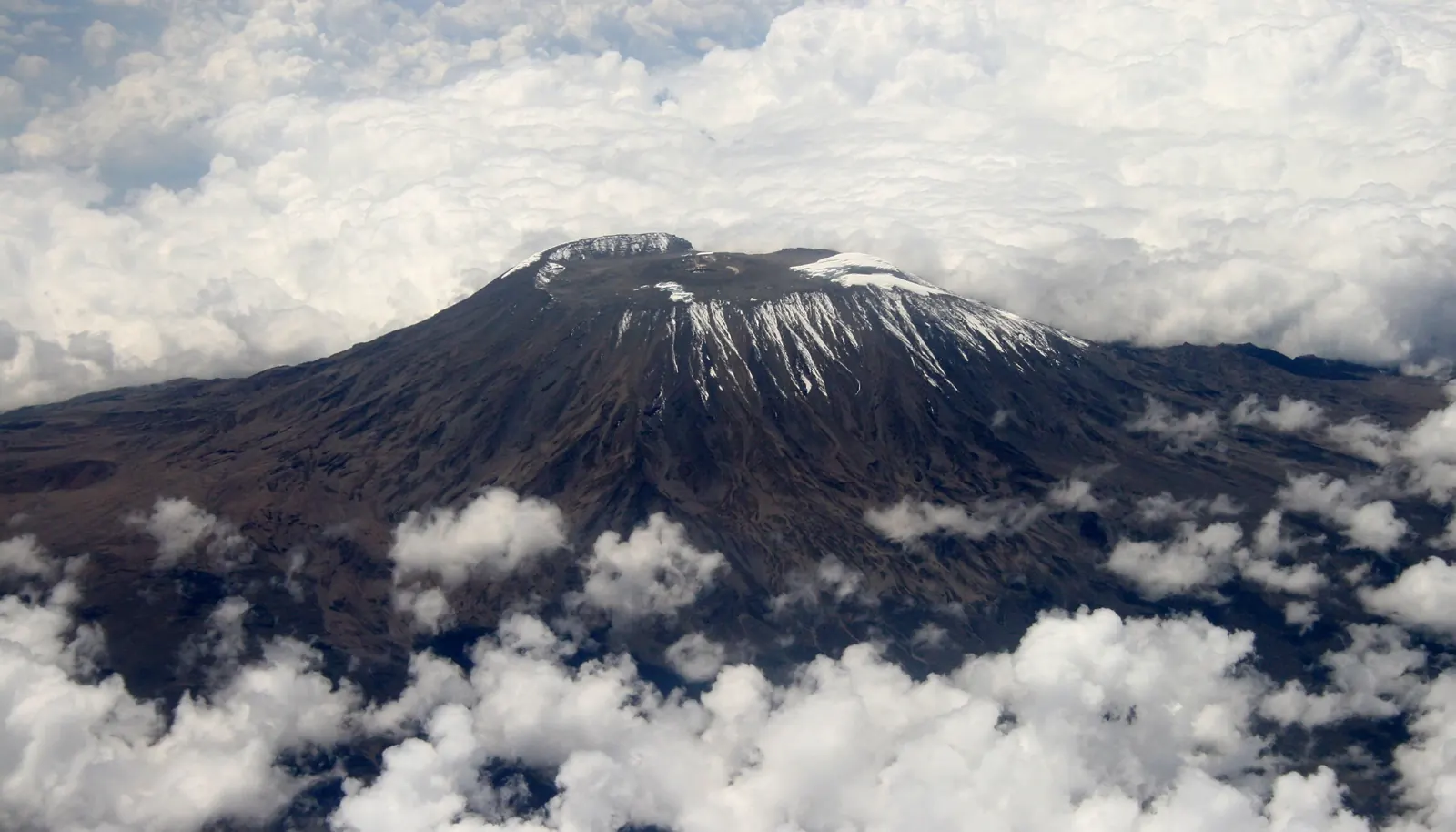 Snow-capped summit of Mount Kilimanjaro above the clouds